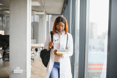 Tıp fakültesi koridorunda Afro-Amerikalı bir kız öğrenci..