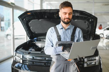 Tamirci Artırılmış Gerçeklik Tanılama Yazılımlı Bilgisayar Kullanıyor. Uzman Uzman Aracın Motorunu Kırık Parçaları Belirlemek İçin Denetliyor. Birinci sınıf araba servisi..