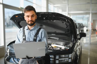 Tamirci Artırılmış Gerçeklik Tanılama Yazılımlı Bilgisayar Kullanıyor. Uzman Uzman Aracın Motorunu Kırık Parçaları Belirlemek İçin Denetliyor. Birinci sınıf araba servisi..