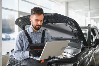 Tamirci Artırılmış Gerçeklik Tanılama Yazılımlı Bilgisayar Kullanıyor. Uzman Uzman Aracın Motorunu Kırık Parçaları Belirlemek İçin Denetliyor. Birinci sınıf araba servisi..