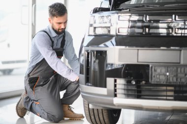 Tamirci garajda çalışıyor ve tekerlek alaşımı değiştiriyor. Tamir ya da bakım servisi. Kış ve yaz lastiklerinin değiştirilmesi.