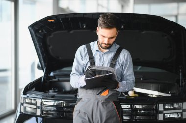 Otomatik tamirci, pano kontrol listesi tamirhanedeki araba, boş pano, tamir makinesi için kontrol listesi yapan teknisyen garajdaki araba.