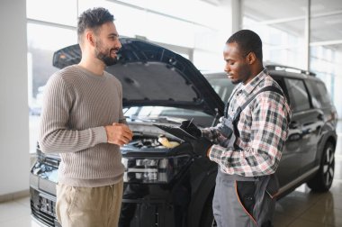 Tatmin olmuş bir müşteri tamir edilmiş arabasını tamirciye götürür. Araba servis istasyonu..