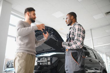 Tamirci çalışma sonucu adam. İstemci bir makinist araba tamiri değerlendirir.