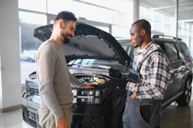 Tatmin olmuş bir müşteri tamir edilmiş arabasını tamirciye götürür. Araba servis istasyonu..