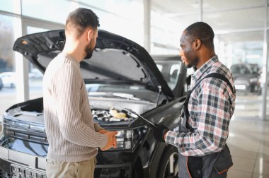 Tamirci çalışma sonucu adam. İstemci bir makinist araba tamiri değerlendirir.