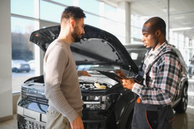 Tatmin olmuş bir müşteri tamir edilmiş arabasını tamirciye götürür. Araba servis istasyonu..