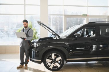 Tamirci Artırılmış Gerçeklik Tanılama Yazılımlı Bilgisayar Kullanıyor. Uzman Uzman Aracın Motorunu Kırık Parçaları Belirlemek İçin Denetliyor. Birinci sınıf araba servisi..