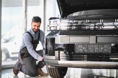 Tamirci garajda çalışıyor ve tekerlek alaşımı değiştiriyor. Tamir ya da bakım servisi. Kış ve yaz lastiklerinin değiştirilmesi.