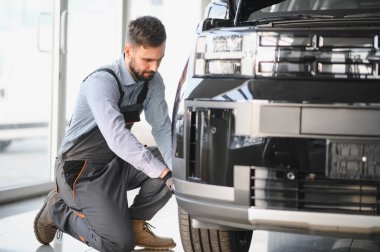 Tamirci garajda çalışıyor ve tekerlek alaşımı değiştiriyor. Tamir ya da bakım servisi. Kış ve yaz lastiklerinin değiştirilmesi.