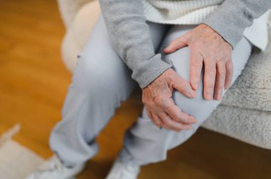 Artrit belirtileri. Diz ağrısı çeken bir kadın..