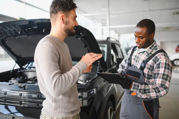 Tatmin olmuş bir müşteri tamir edilmiş arabasını tamirciye götürür. Araba servis istasyonu..