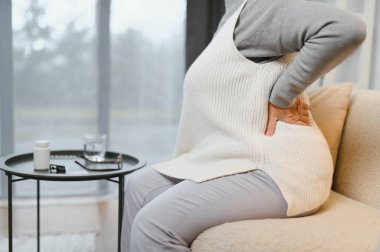 üst düzey kadın evde sırt ağrısı muzdarip.