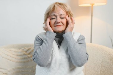 Yaşlı kadın baş ağrısı çekiyor..