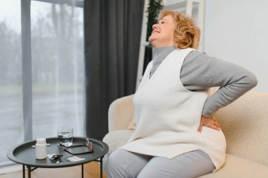 üst düzey kadın evde sırt ağrısı muzdarip.