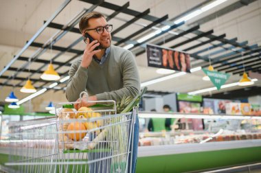 Arabalı bir adam süpermarkette yürür..