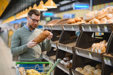 Yakışıklı adam bir süpermarkette alışveriş.