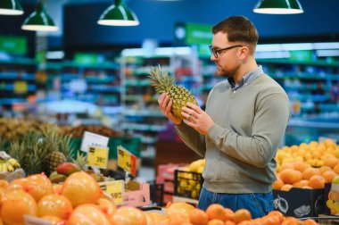 Yakışıklı adam bir süpermarkette alışveriş.