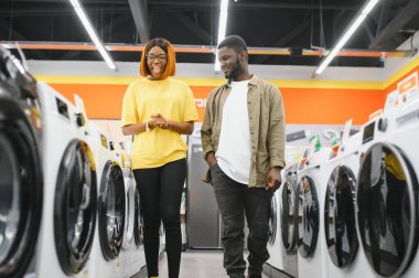 Mutlu genç gülümseyen hipermarket seçerek çamaşır makinesi çift.