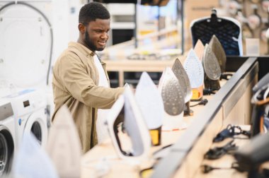 Depoda elektrikli demir seçen bir adam.