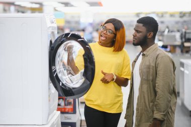 Mutlu genç gülümseyen hipermarket seçerek çamaşır makinesi çift.