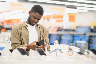 Genç erkek müşteri smartphone cep telefonu dükkanında seçimi görünümünü kapat