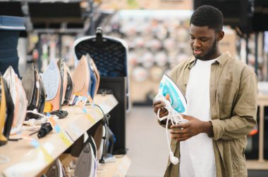 Depoda elektrikli demir seçen bir adam.