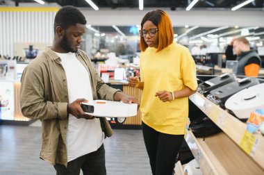 Mağazadan kablosuz elektrik süpürgesi alan çift.