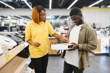 Genç çift, tatmin olmuş müşteriler elektrikli süpürge satın alıyorlar..