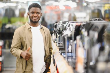 Alışveriş merkezinde kahve makinesini seçen adam..