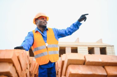 Construction african american worker in uniform and safety equipment have job on building clipart