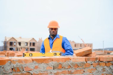 Çimento Sanayi işçisi tuğla duvar dış duvarda mala macun bıçak ile yükleme