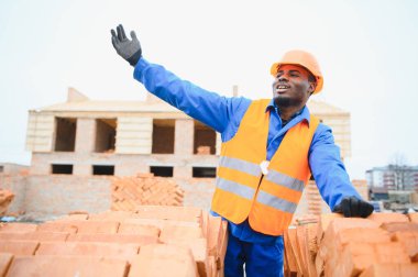 Construction african american worker in uniform and safety equipment have job on building clipart