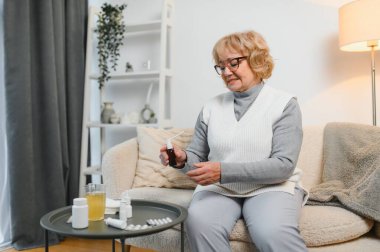 Boğaz ağrısı. Yaşlı kadın evde boğaz spreyi kullanıyor..