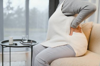 üst düzey kadın evde sırt ağrısı muzdarip.