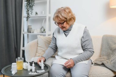 Kafkasyalı hasta, olgun bir kadın evde kanepede oturur, yorgun ve üzgün görünür. Evde soğuk algınlığı ve grip tedavisi