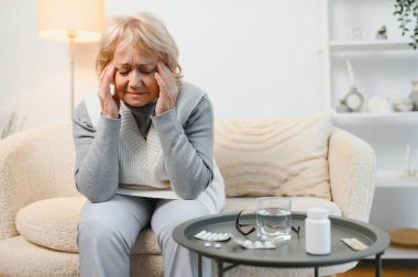 Yaşlı kadın baş ağrısı çekiyor..