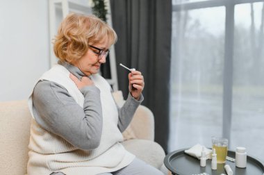 Üst düzey hasta kadın evde sprey kullanarak. Anti kavramı.