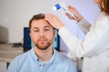 Bir tricholog, saç dökülmesine başlayan bir adamın saçını inceliyor. Bir dermatologla görüşeceğim. Saç dökülmesi, alopezi, pruritus, yanmakta olan kafa ya da sebora.