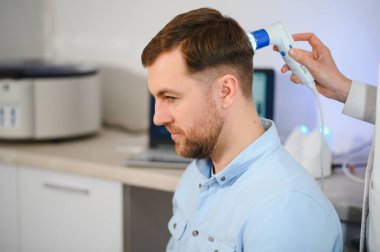 Genç bir adamın saç, kafa derisi ve saç foliküllerinin trikop incelemesi. Boşluk afişini kopyala.