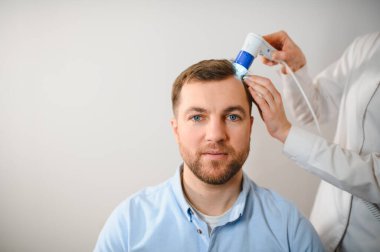 Genç bir adamın saç, kafa derisi ve saç foliküllerinin trikop incelemesi. Boşluk afişini kopyala.