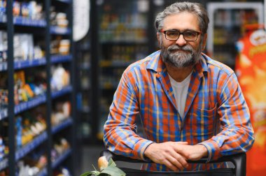 Market ürünlerinde kıdemli adam..