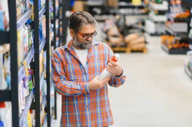 Erkek müşteri süpermarketten alışveriş yapıyor, ev yapımı kimyasallar alıyor..