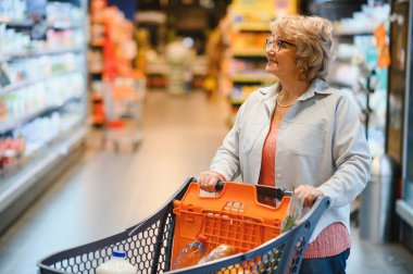 Süpermarkette son sınıf öğrencisi mutlu bir kadın portresi.