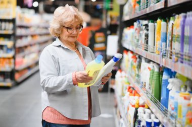 Evdeki kimyasallardan alışveriş yapan, şişelerdeki etiketleri okuyan ilginç bir kadın..