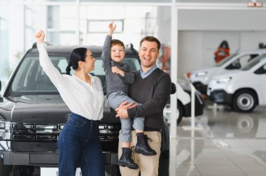 Mutlu bir aile araba galerisinden yeni bir araba alıyor..