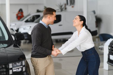 Galeriye başarılı bir ziyaret. Mutlu genç çift aile için yeni bir araba seçer ve alır..