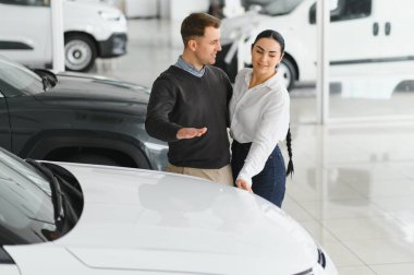 Araba galerisinde yeni bir araba seçen güzel bir çiftin portresi..