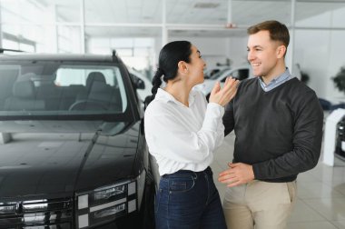 Araba galerisinde yeni bir araba seçen güzel bir çiftin portresi..