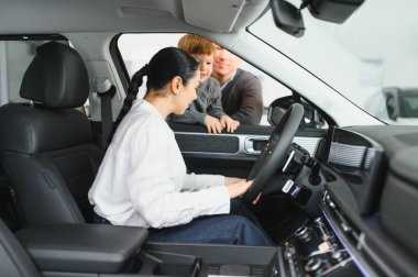 Genç, beyaz bir aile bayilikten araba seçiyor. En rahat ve güvenli arabayı istiyorlar.